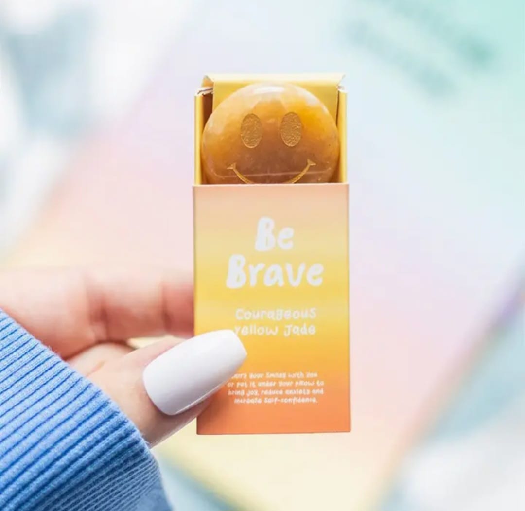 geel gekleurde luciferdoosje met de tekst be brave en daarin zit een gele jade edelsteen edelsteen met een lachend gezichtje