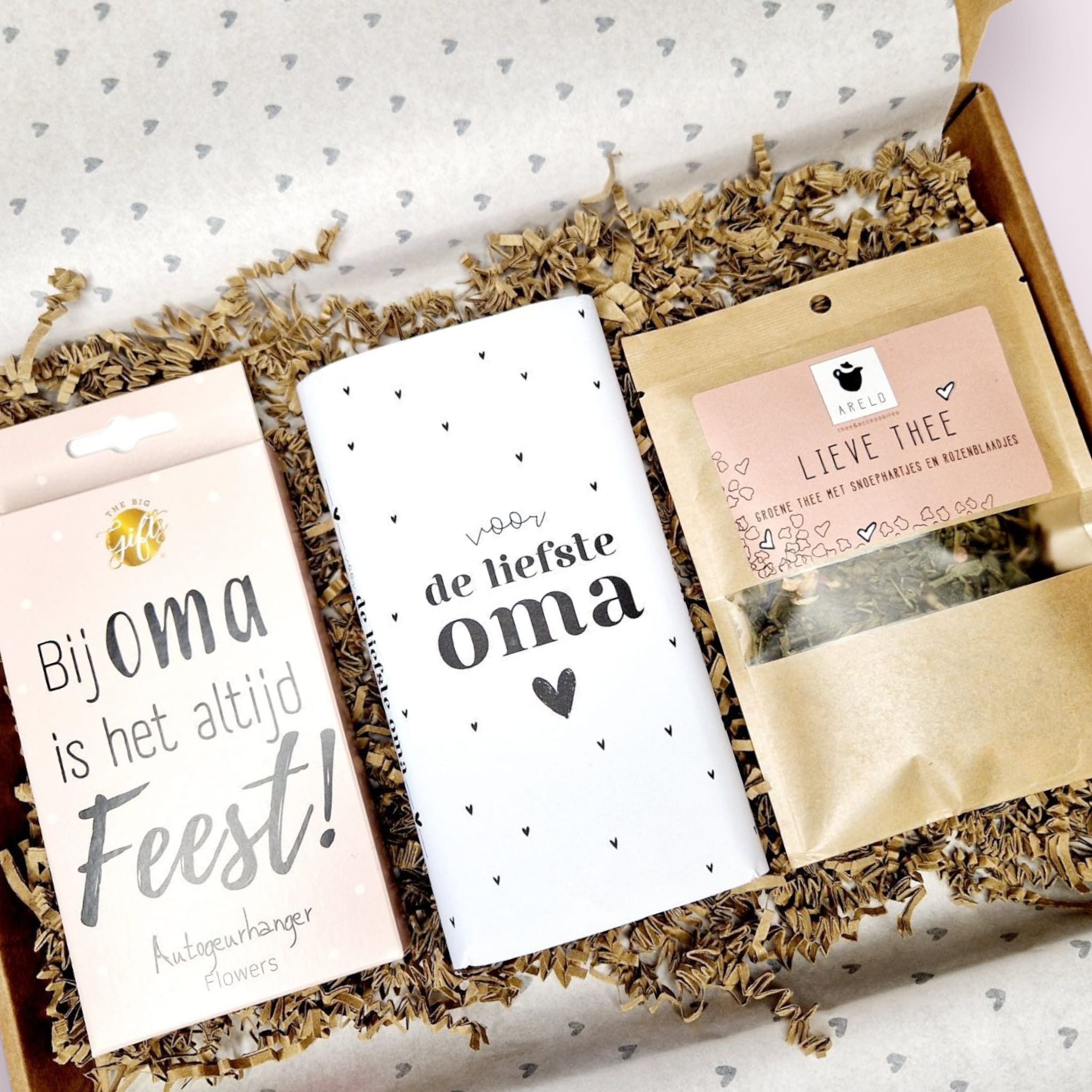 brievenbuscadeau geuld met een autogeurhanger met de tekst bij oma is het altijd feest, een chocoladereep met de tekst voor de liefste oma en losse thee in een zak met de tekst lieve thee