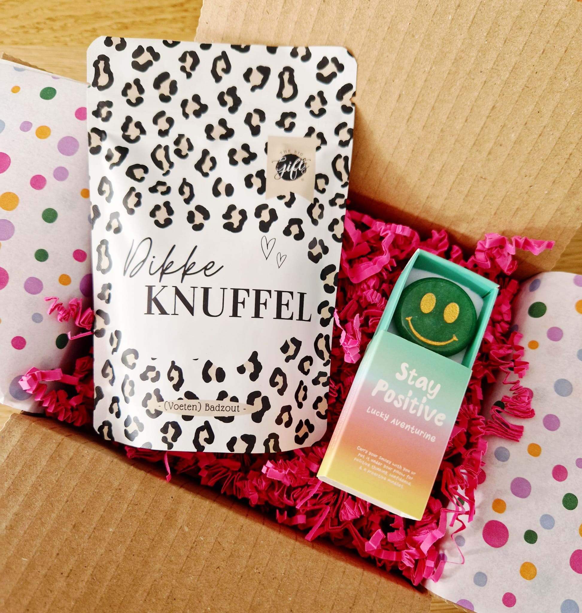 brievenbuscadeaupakket met badzout met de tekst dikke knuffel en een edelsteen in de vorm van een rondje, een smiley erop gedrukt en in het groen met de tekst stay positive