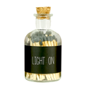 glazen flesje gevuld met lucifers en de tekst light on