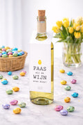 fles met witte wijn en een witte flessenhanger eraan met de tekst paas mij de wijn even door!