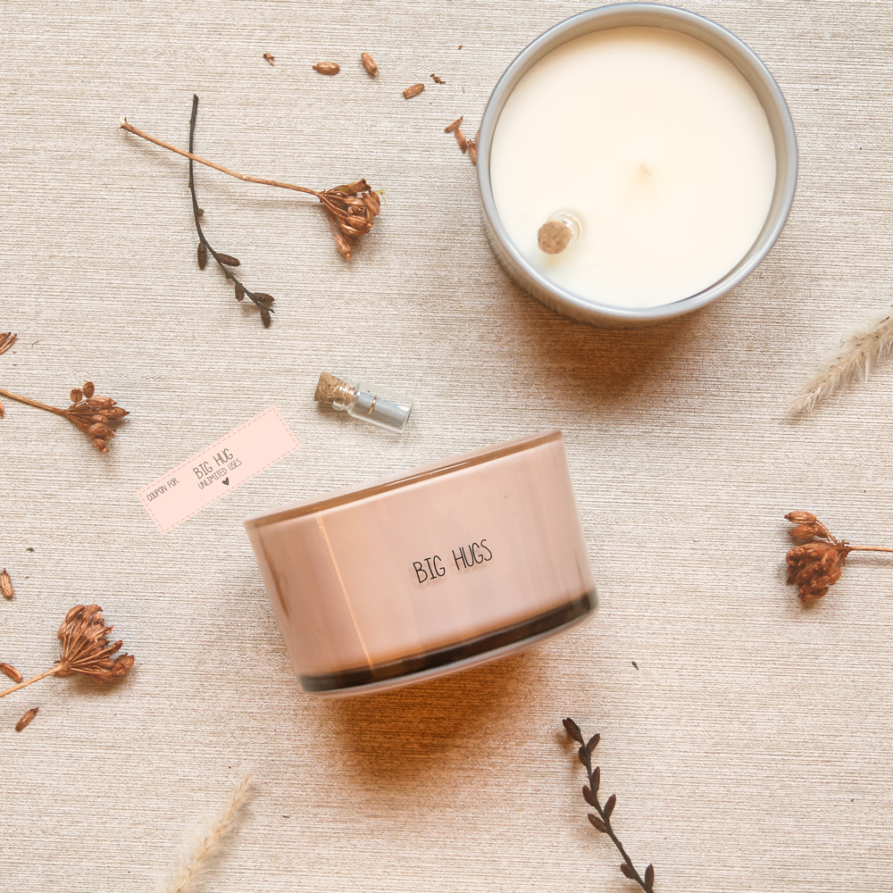 Glazen pot gevuld met sojawas en een flessenpost. Op de glazen pot staat big hugs