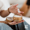Open pot bodybutter met een dotje boter op de vingers