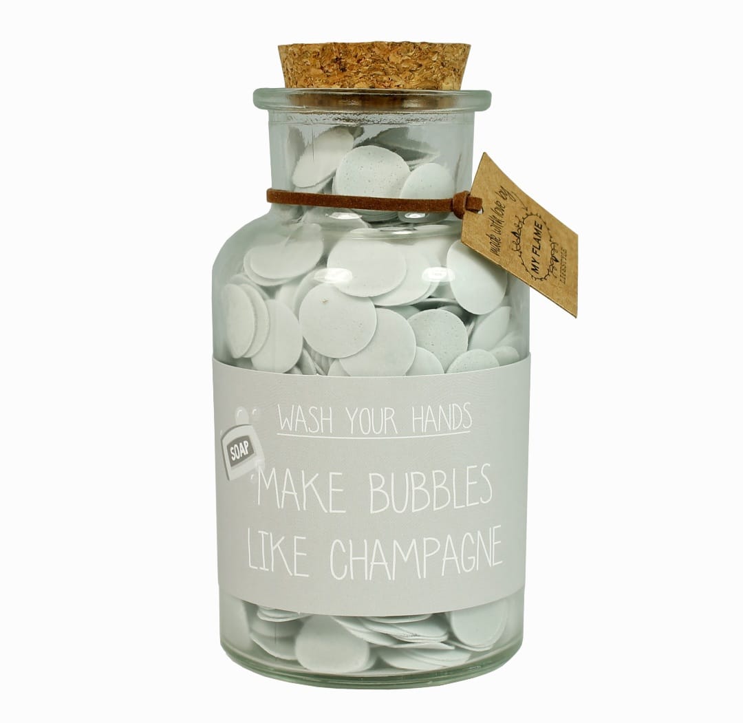 Een glazen fles met confetti handzeep en de tekst make bubbles like champagne