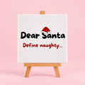 Witte keramieken tegel met de tekst dear santa define naughty