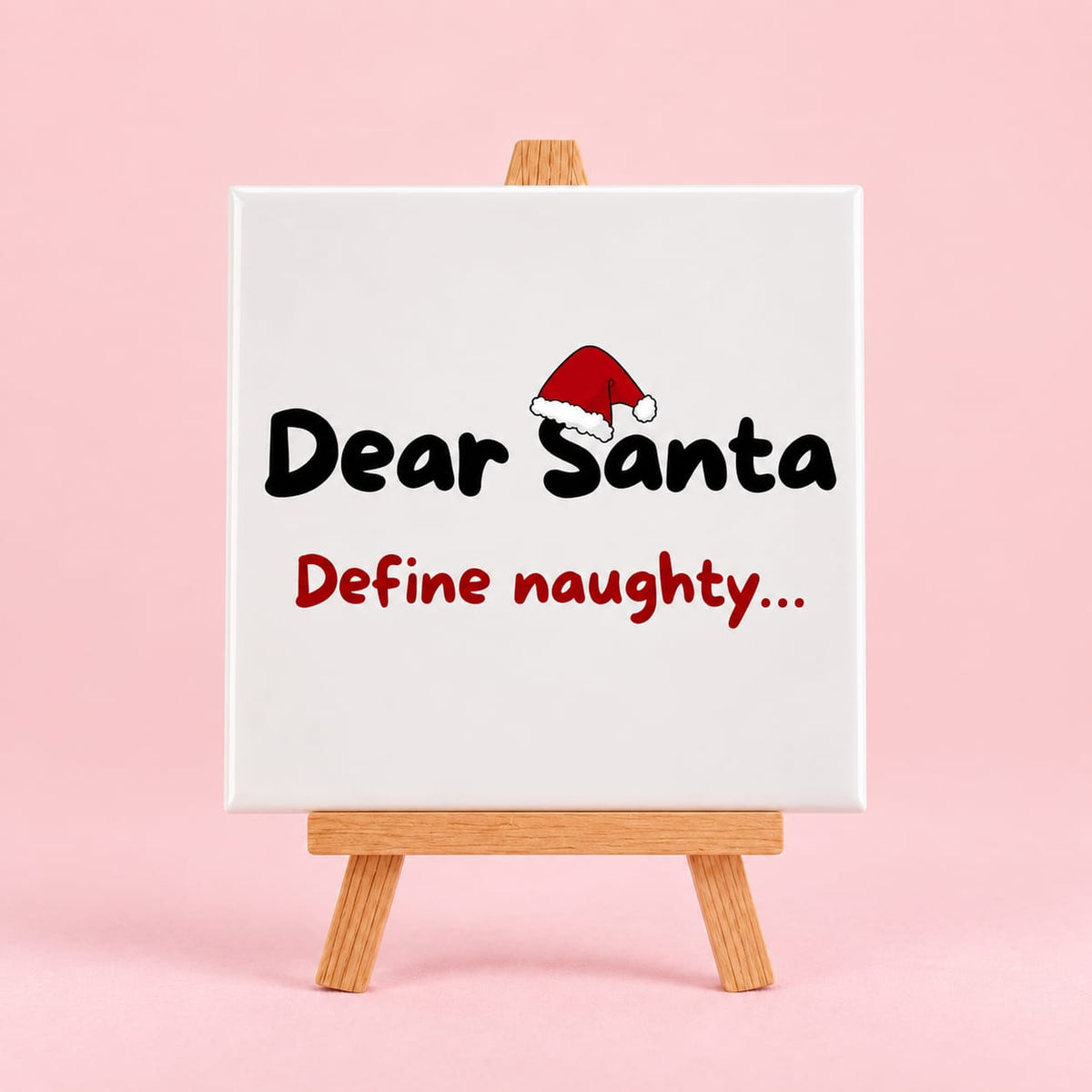 Witte keramieken tegel met de tekst dear santa define naughty