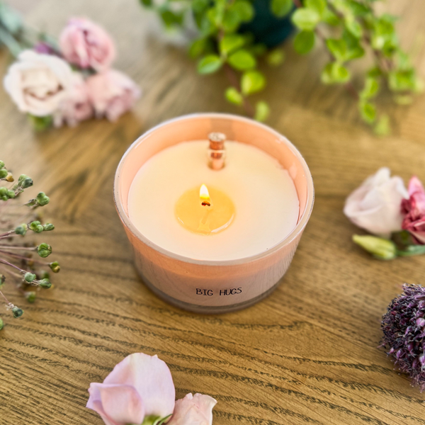 Glazen pot gevuld met sojawas en een flessenpost. Op de glazen pot staat big hugs