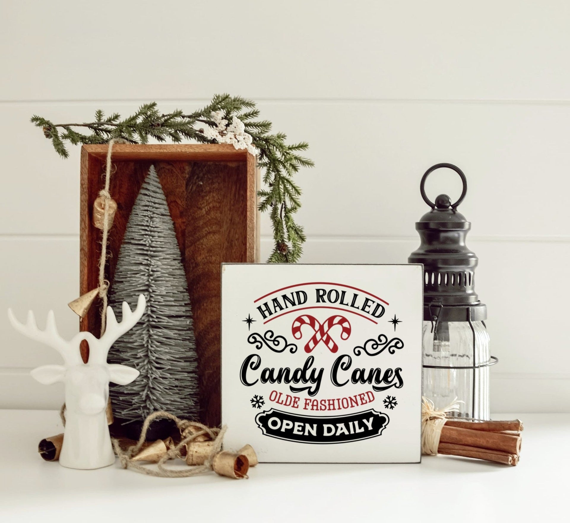 wit houten blok met candy canes en de tekst hand rolled candy canes