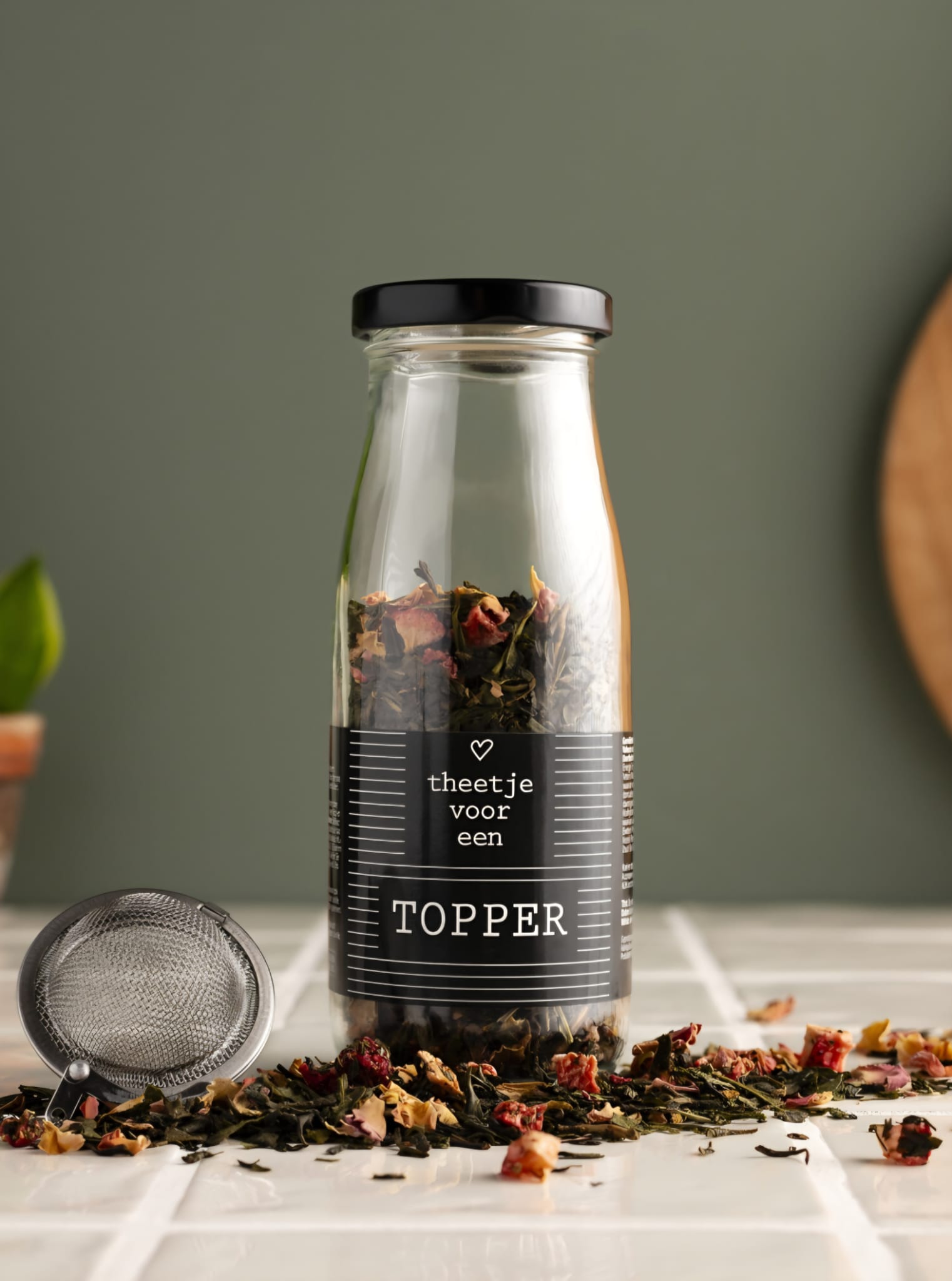 glazen flesje losse thee met de tekst theetje voor een topper