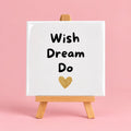 Witte keramieken tegel met de tekst wish dream do
