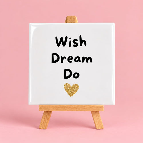 Witte keramieken tegel met de tekst wish dream do